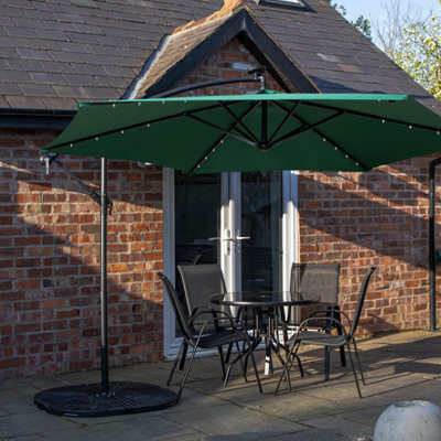 Samuel Alexander Outdoor 4 Person Round Glass Top Garden Dining Table Chairs With Green Banana Lit Parasol And Base - image 1