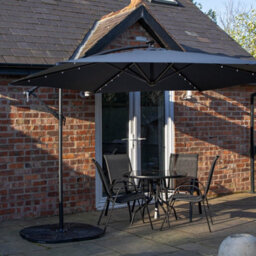 Samuel Alexander Outdoor 4 Person Round Glass Top Garden Dining Table Chairs With Blue Banana Lit Parasol And Base