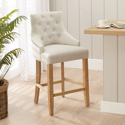 The Furniture Market Luxury Natural Fabric Scoop Back Kitchen Counter Bar Stool Limed Oak Legs Quilted Button Back Stud Detailing Solid Wood Frame - image 1