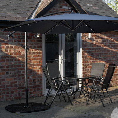 Samuel Alexander Outdoor 4 Person Round Glass Top Garden Dining Table Chairs With Blue Banana Lit Parasol And Base Set - image 1