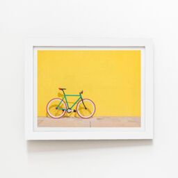 "Warren Reed - Designer Bike Against Yellow Framed Art Print in White - Size: W24"" x H36""" - thumbnail 1