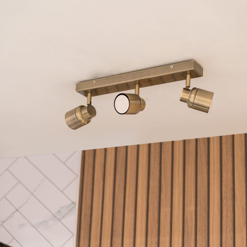 Benton IP44 3 Way Bar Bathroom Spotlight Ceiling Light In Antique Brass - image 1