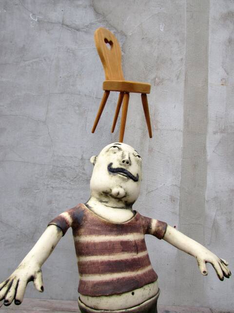 Ceramic Juggler Balancing A Hand Carved Chair - image 1