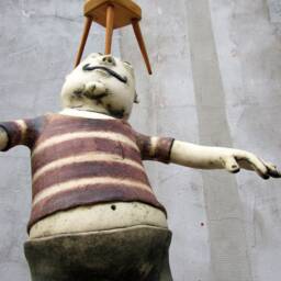 Ceramic Juggler Balancing A Hand Carved Chair - thumbnail 2