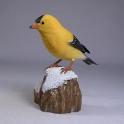 American Goldfinch On Wooden Snowy Base - thumbnail 2