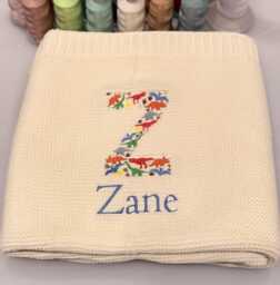 Dino Baby Blanket, Embroidered Dinosaur Alphabet, Knit Newborn Gift, Knitted Blanket For Pram, Custom Name - thumbnail 1