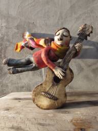 Ceramic Flying Guitarist Wearing A Hand Knitted Striped Scarf - thumbnail 1