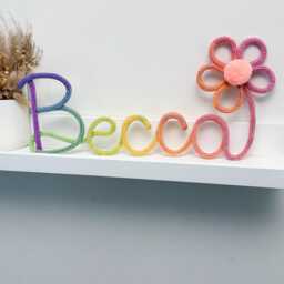 Rainbow Knitted Name Sign Nursery Decor With Flower & Pom-Pom - thumbnail 2