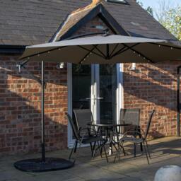 Rackhams Outdoor 4 Person Round Glass Top Garden Dining Table Chairs With Grey Banana Lit Parasol and Base