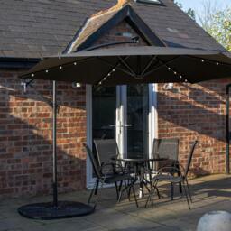 Rackhams Outdoor 4 Person Round Glass Top Garden Dining Table Chairs With Black Banana Lit Parasol and Base - thumbnail 1