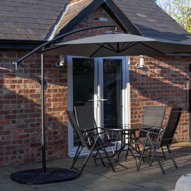 Samuel Alexander 4 Person Round Glass Top Garden Dining Set with Grey Banana Parasol and Base - Size: 4 Seater - Black - Wilko - image 1