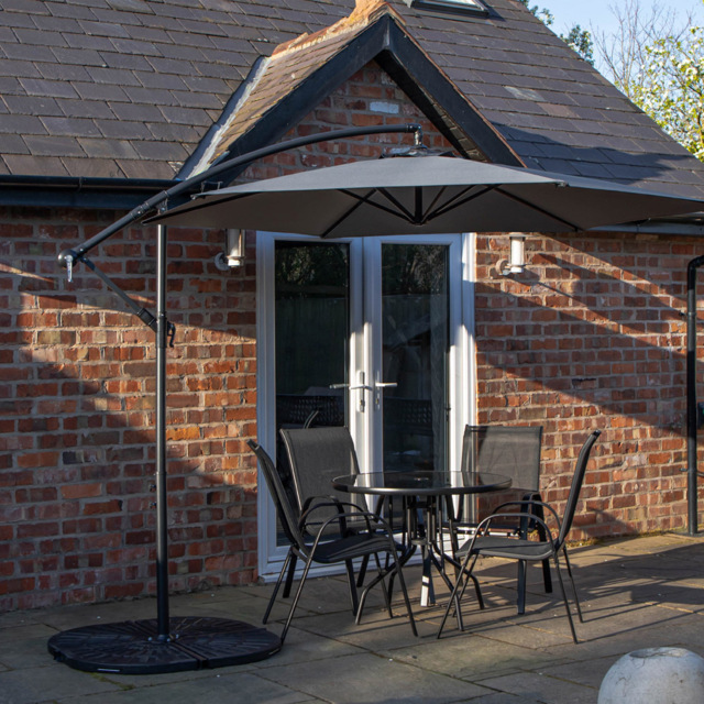 Samuel Alexander 4 Person Round Glass Top Garden Dining Set with Grey Banana Parasol - Size: 4 Seater - Black - Wilko - image 1